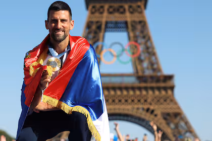 París 2024: Djokovic, arropado por la bandera de Serbia, celebrando el oro olímpico en singles, el único título grande que le faltaba
