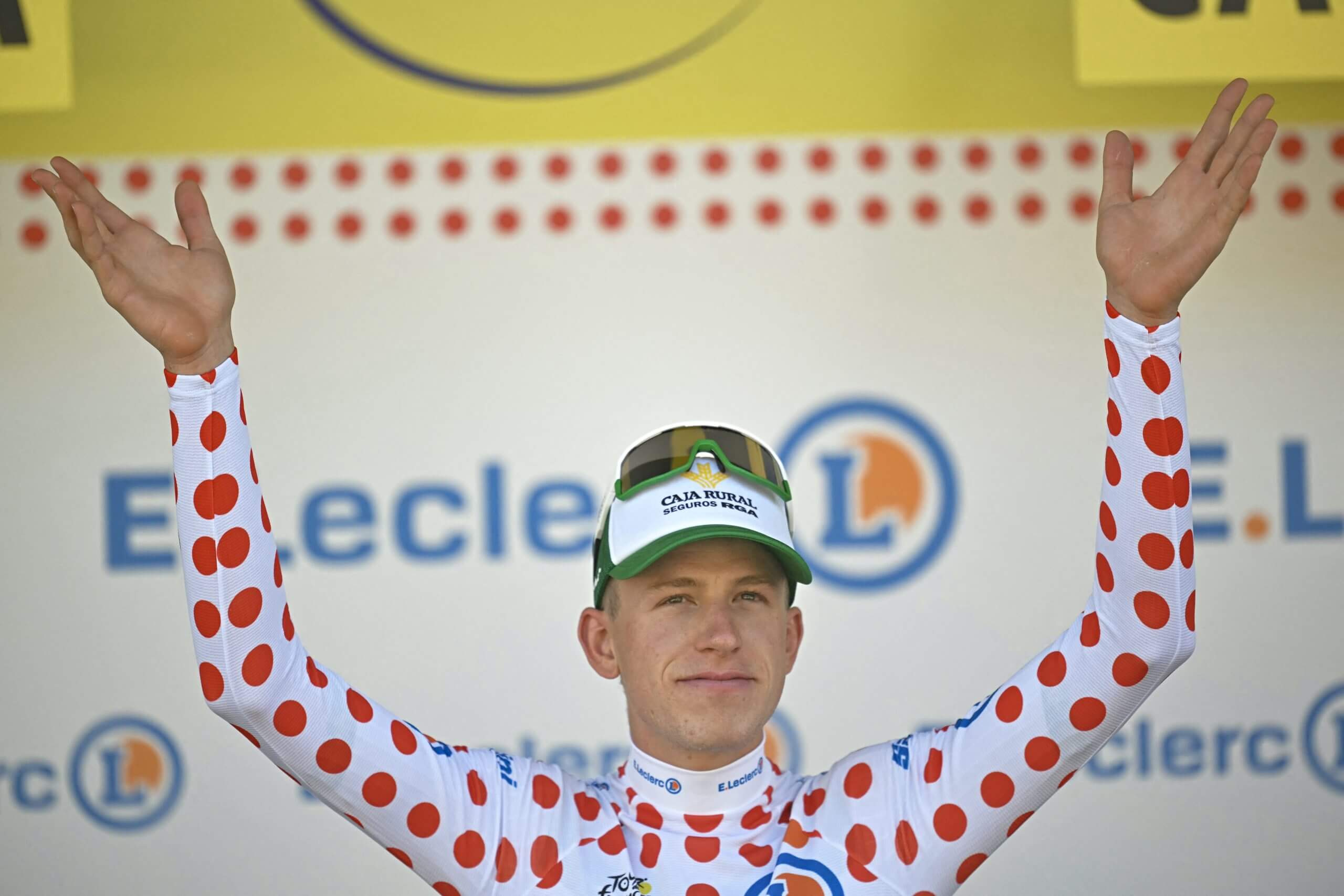 Alex Molenaar, clad in the polka dot jersey, holds his hands aloft as he celebrates his current Kong of the Mountains classification