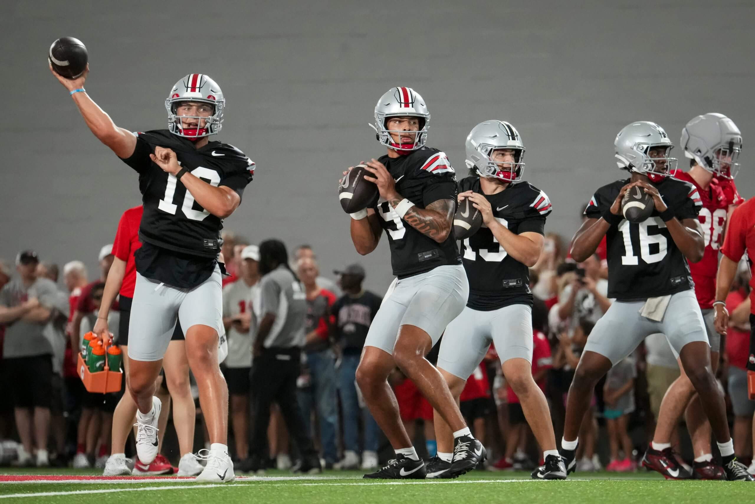 Ohio State quarterbacks Julian Sayin, Tavien St. Clair, Luke Fahey and Justyn Martin throw during a training camp.