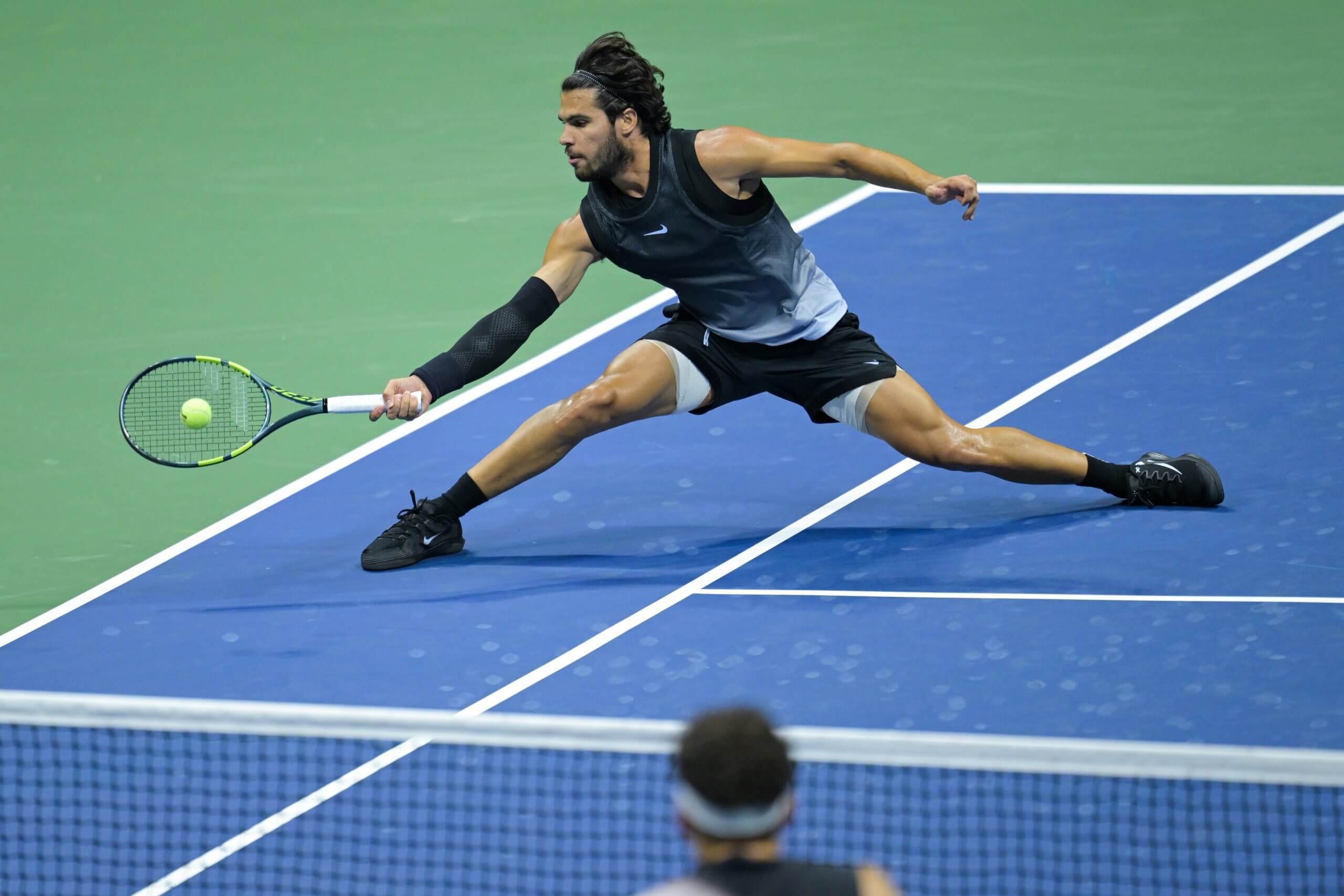 Carlos Alcaraz hits a sliding forehand against Ben Shelton.